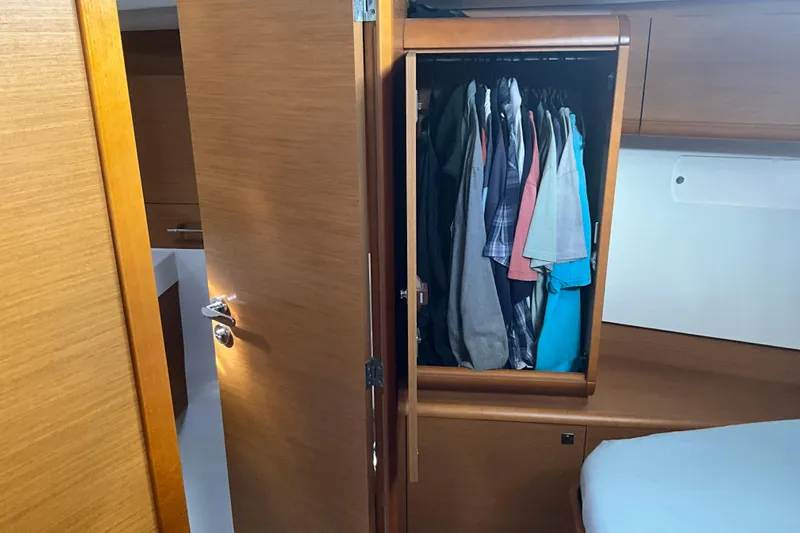Epicurios Yacht Photos Pics Interior of 2015 Jeanneau Sun Odyssey 469 yacht with open wardrobe and clothes.