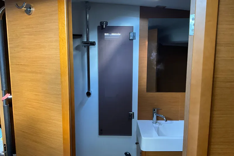 Epicurios Yacht Photos Pics 2015 Jeanneau Sun Odyssey 469 bathroom with modern sink and wooden accents.