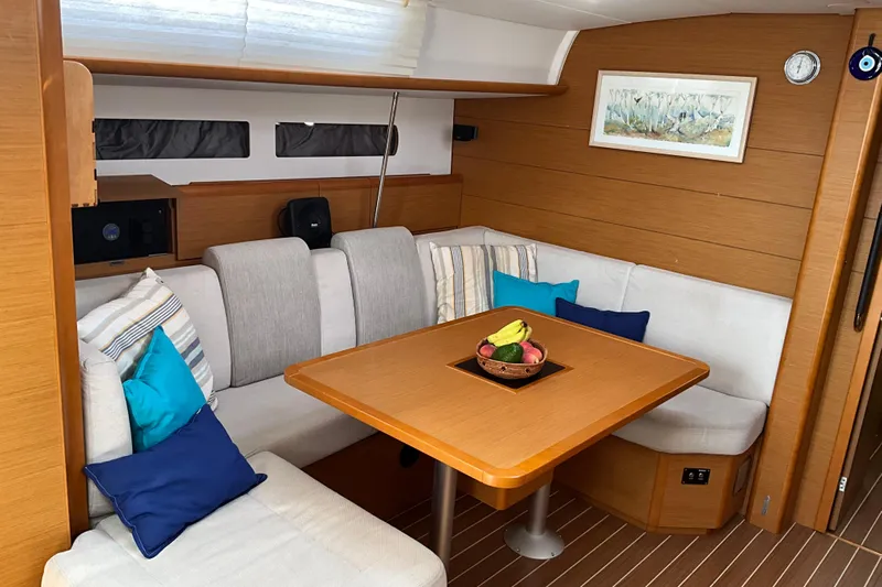 Epicurios Yacht Photos Pics Cozy interior of 2015 Jeanneau Sun Odyssey 469 sailboat with dining area and cushions.