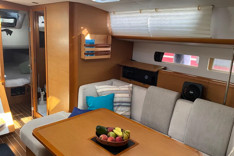 Epicurios Yacht Photos Pics Interior of 2015 Jeanneau Sun Odyssey 469 yacht with cozy seating and fruit bowl.