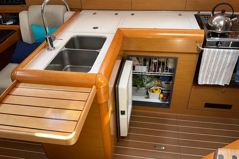 Epicurios Yacht Photos Pics Modern kitchen in 2015 Jeanneau Sun Odyssey 469 yacht with sink, fridge, and stove.