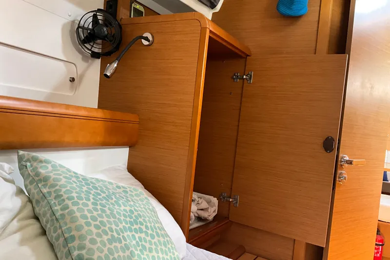 Epicurios Yacht Photos Pics Interior cabin of 2015 Jeanneau Sun Odyssey 469 yacht with wooden cabinetry and cozy bedding.