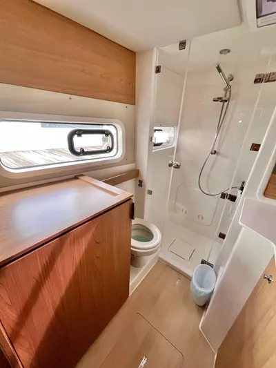 Tropicat Yacht Photos Pics 2024 Bali Catspace 40 bathroom with shower, toilet, and wooden cabinetry.