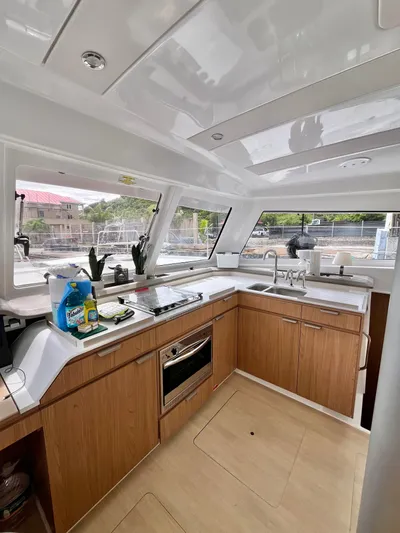 Tropicat Yacht Photos Pics Modern kitchen interior of 2024 Bali Catspace 40 catamaran with wood cabinetry and large windows.