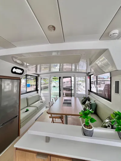 Tropicat Yacht Photos Pics 2024 Bali Catspace 40 interior with modern seating, dining table, and potted plants.