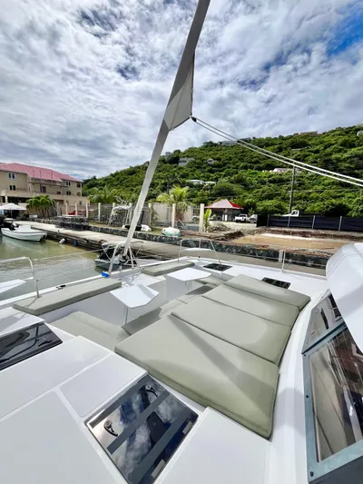 Tropicat Yacht Photos Pics 2024 Bali Catspace 40 catamaran with spacious deck, docked near lush green hillside.