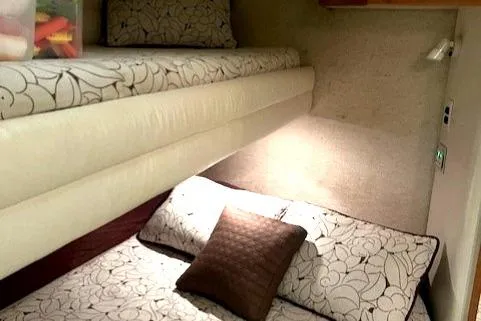 To Come Yacht Photos Pics Interior cabin of a 1992 Sea Ray Sundancer with bunk beds and floral bedding.