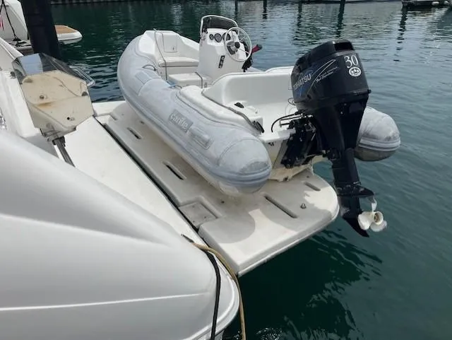 To Come Yacht Photos Pics 1992 Sea Ray Sundancer with inflatable dinghy and outboard motor on swim platform.