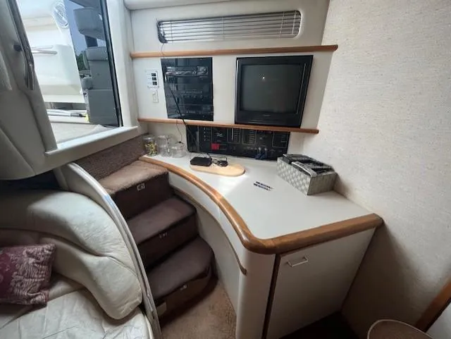 To Come Yacht Photos Pics 1992 Sea Ray Sundancer cabin interior with TV, stereo, and storage.