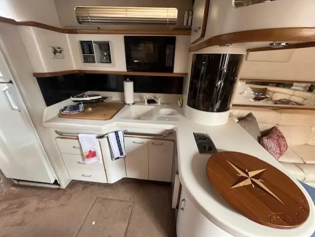 To Come Yacht Photos Pics 1992 Sea Ray Sundancer kitchen area with modern appliances and wooden accents.