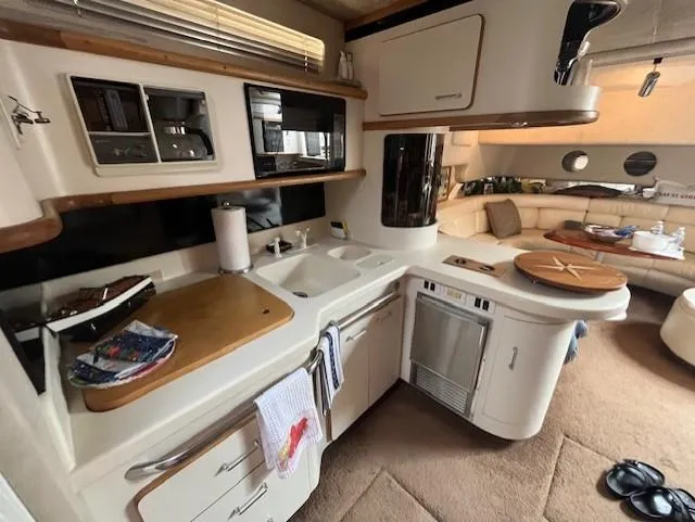 To Come Yacht Photos Pics 1992 Sea Ray Sundancer yacht interior kitchen with modern amenities and cozy seating area.