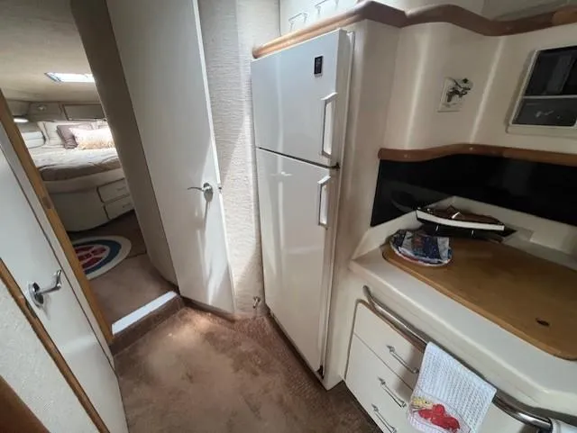To Come Yacht Photos Pics 1992 Sea Ray Sundancer interior kitchen area with refrigerator and bedroom view.