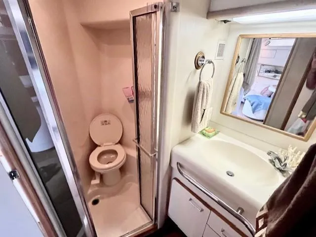 To Come Yacht Photos Pics 1992 Sea Ray Sundancer bathroom with shower, toilet, sink, and mirror.