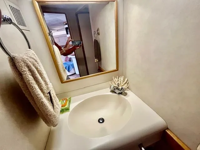 To Come Yacht Photos Pics 1992 Sea Ray Sundancer bathroom with sink, mirror, towel, and soap.