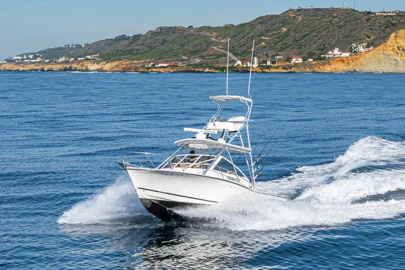 Jesse Girl Yacht Photos Pics 2005 Carolina Classic 28 boat cruising on ocean near rocky coastline.