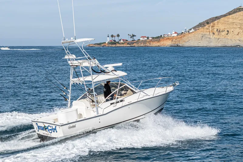 Jesse Girl Yacht Photos Pics 2005 Carolina Classic 28 boat cruising near rocky coastline.