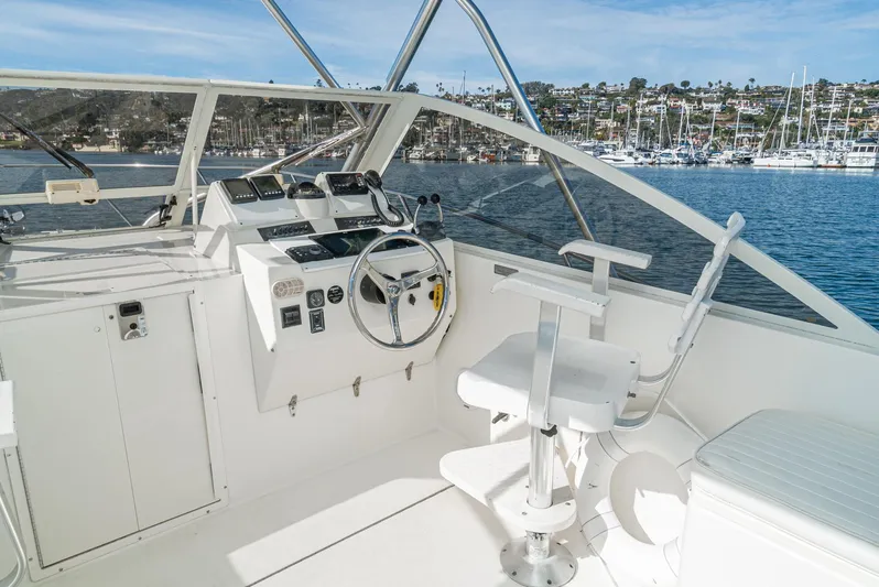 Jesse Girl Yacht Photos Pics 2005 Carolina Classic 28 boat helm with steering wheel, controls, and seating, overlooking marina.
