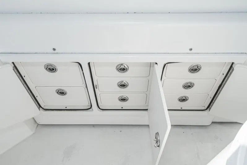 Jesse Girl Yacht Photos Pics Storage compartments on a 2005 Carolina Classic 28 boat, featuring multiple white drawers.