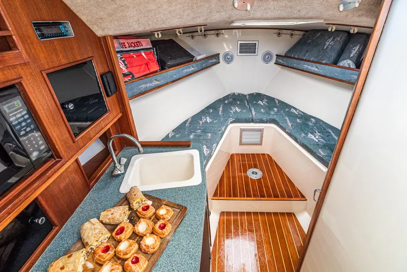 Jesse Girl Yacht Photos Pics 2005 Carolina Classic 28 cabin interior with kitchenette, sink, and cozy sleeping area.