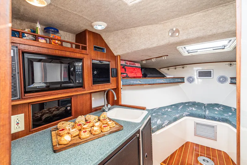 Jesse Girl Yacht Photos Pics 2005 Carolina Classic 28 boat interior with kitchenette and cozy sleeping area.