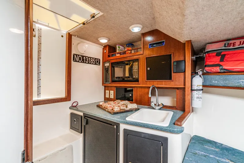 Jesse Girl Yacht Photos Pics 2005 Carolina Classic 28 boat interior with kitchenette, sink, and storage.
