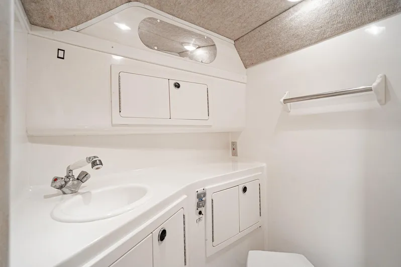 Jesse Girl Yacht Photos Pics 2005 Carolina Classic 28 boat bathroom with white cabinetry and sink.