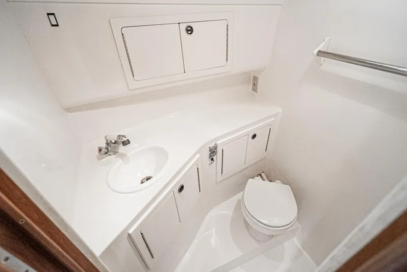 Jesse Girl Yacht Photos Pics 2005 Carolina Classic 28 boat bathroom with sink, toilet, and storage cabinets.