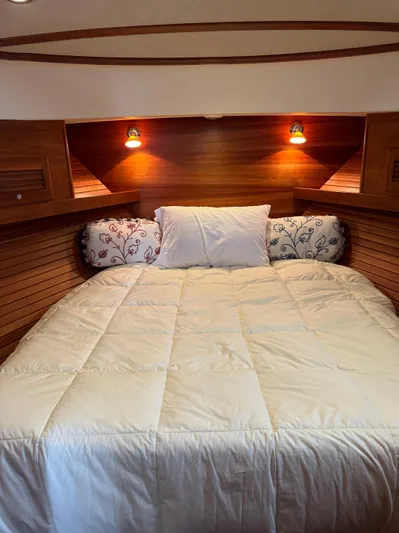  Yacht Photos Pics Cozy cabin bedroom in 2010 Sabre 40 Sedan yacht with wooden walls and soft lighting.