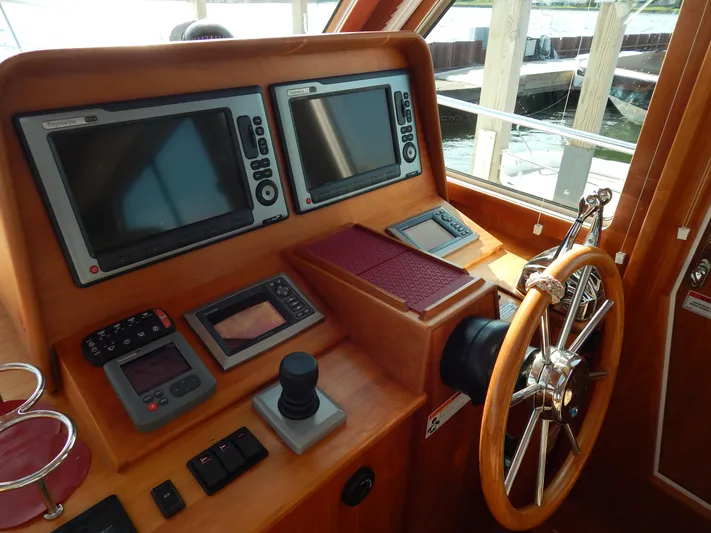  Yacht Photos Pics Helm of 2010 Sabre 40 Sedan with navigation screens and wooden steering wheel.