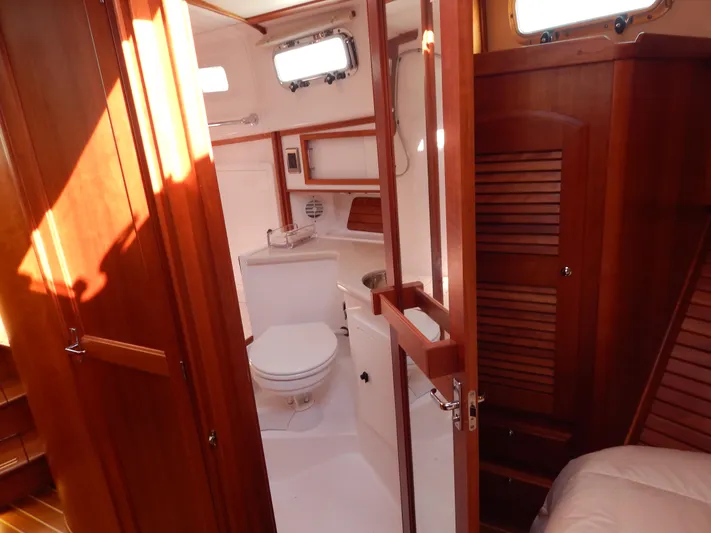  Yacht Photos Pics 2010 Sabre 40 Sedan yacht bathroom with wooden cabinetry and white fixtures.