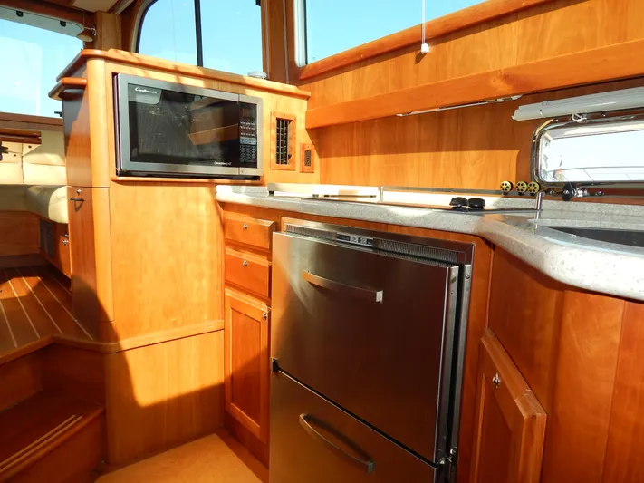  Yacht Photos Pics 2010 Sabre 40 Sedan yacht kitchen with wood cabinetry, microwave, and stainless steel fridge.