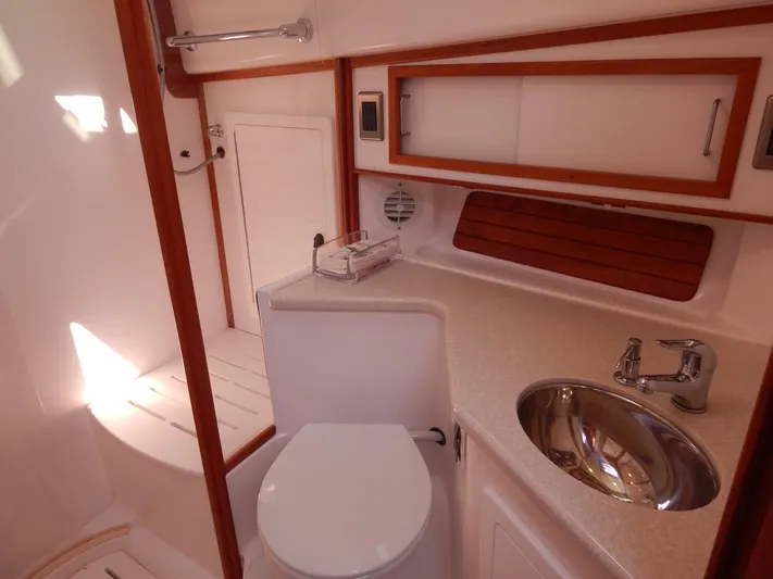  Yacht Photos Pics 2010 Sabre 40 Sedan yacht bathroom with sink, toilet, and wooden accents.