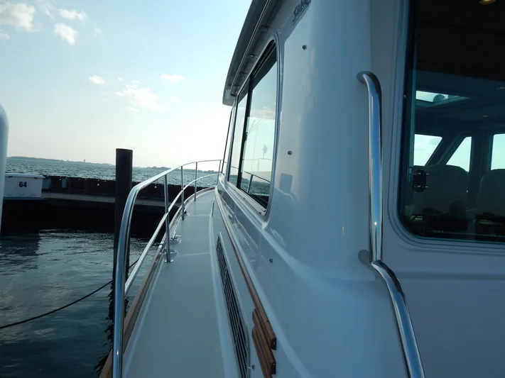  Yacht Photos Pics 2010 Sabre 40 Sedan yacht docked at marina, side view with railing and windows.