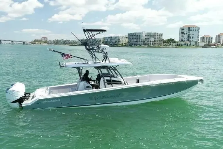  Yacht Photos Pics 2020 Nor-Tech 390 boat cruising on clear waters near coastal buildings.