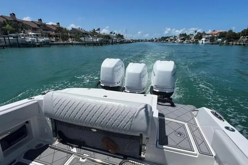  Yacht Photos Pics 2020 Nor-Tech 390 boat cruising on a scenic waterway with triple outboard engines.