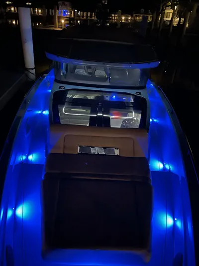  Yacht Photos Pics 2022 Axopar Brabus Shadow 900 XC boat with vibrant blue LED lights at night.