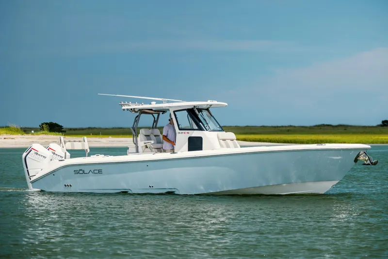  Yacht Photos Pics 2024 Solace 32 CS boat cruising on calm water near a sandy shoreline.