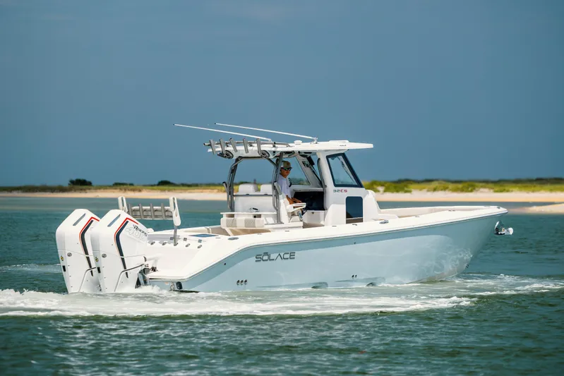  Yacht Photos Pics 2024 Solace 32 CS boat cruising on water with dual engines, clear sky background.