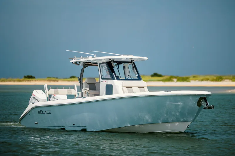  Yacht Photos Pics 2024 Solace 32 CS boat cruising on calm waters near a sandy shoreline.