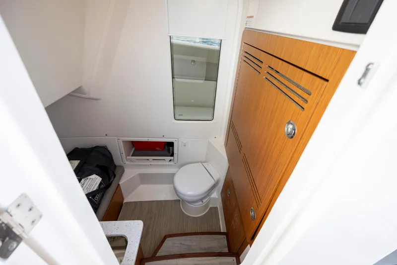  Yacht Photos Pics 2024 Solace 32 CS boat interior with compact bathroom and wooden cabinetry.