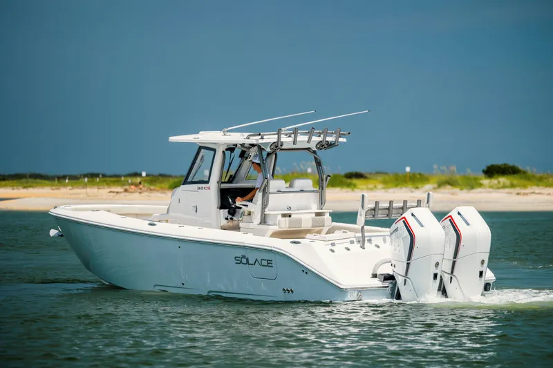  Yacht Photos Pics 2024 Solace 32 CS boat cruising on water near a sandy shoreline.