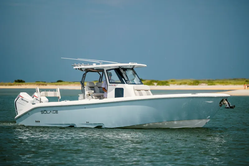  Yacht Photos Pics 2024 Solace 32 CS boat cruising on water near a sandy shoreline.