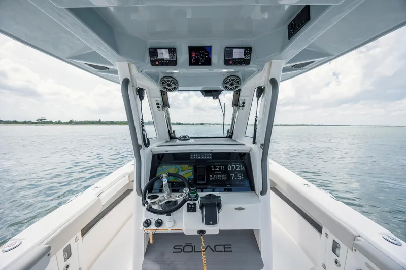  Yacht Photos Pics 2024 Solace 32 CS boat helm with advanced navigation system on open water.