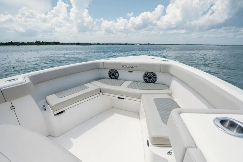  Yacht Photos Pics 2024 Solace 32 CS boat interior with cushioned seating, ocean view, and clear sky.