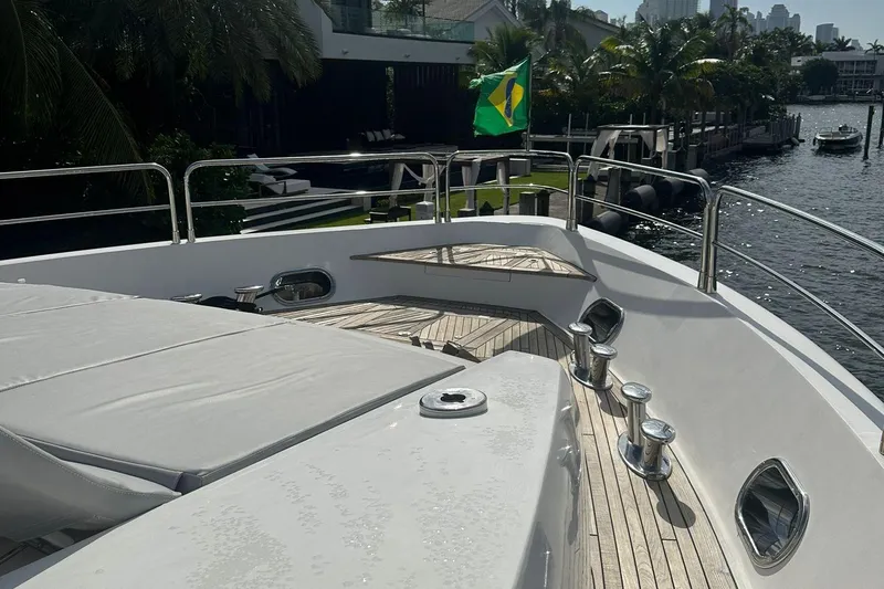 Blue Yacht Photos Pics Luxury Azimut 112 yacht deck with Brazilian flag, docked by waterfront homes.