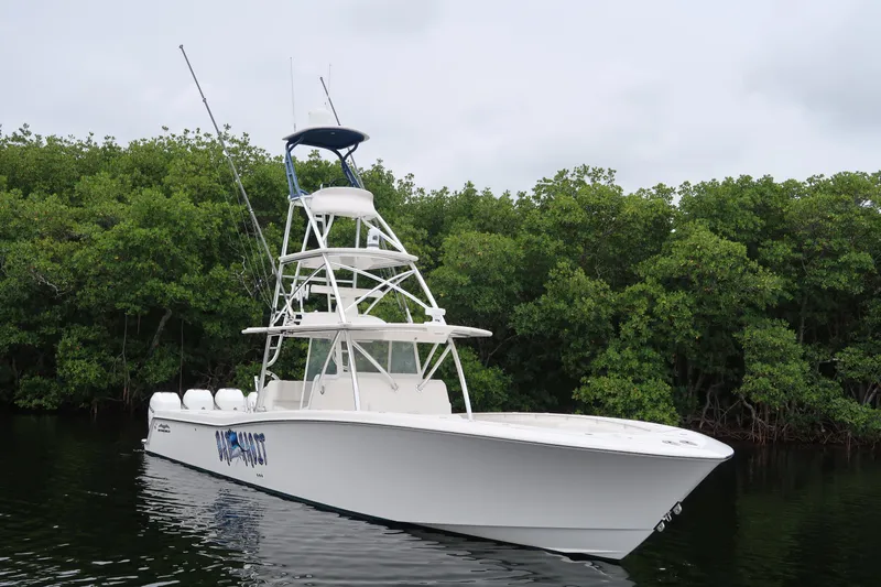 Bad Habit Yacht Photos Pics 2016 Invincible 42 Open Fisherman boat on calm water near lush greenery.