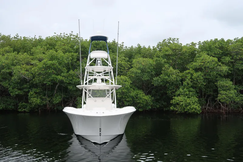 Bad Habit Yacht Photos Pics 2016 Invincible 42 Open Fisherman boat on calm water with lush green background.