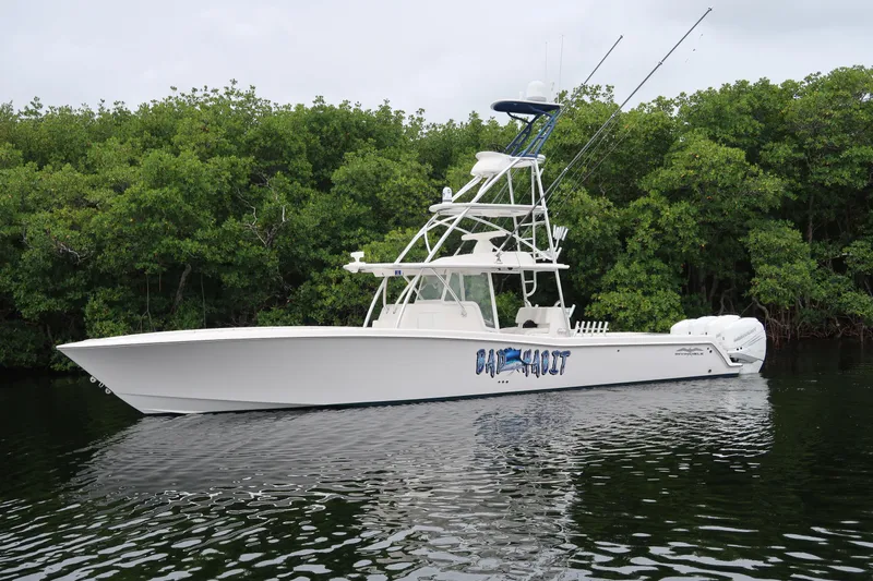Bad Habit Yacht Photos Pics 2016 Invincible 42 Open Fisherman boat on calm water near lush greenery.