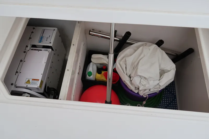 Bad Habit Yacht Photos Pics Storage compartment of a 2016 Invincible 42 Open Fisherman boat with cleaning supplies.