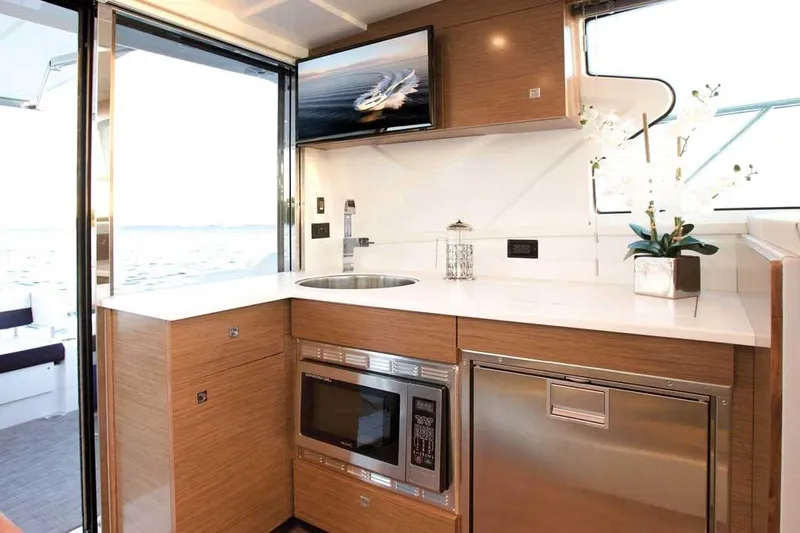 Sargam Yacht Photos Pics Modern kitchen interior of 2023 Cruisers 42 Cantius yacht with sleek appliances and elegant design.